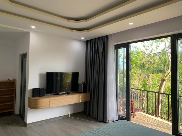 Không gian trong nhà với cửa mở ra ban công xanh